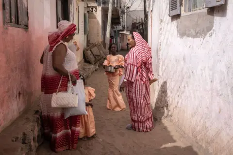 JOHN WESSELS/AFP  Women dressed in traditional attire gather during Tabaski (Eid al-Adha) celebrations in Dakar on June 17, 2024.