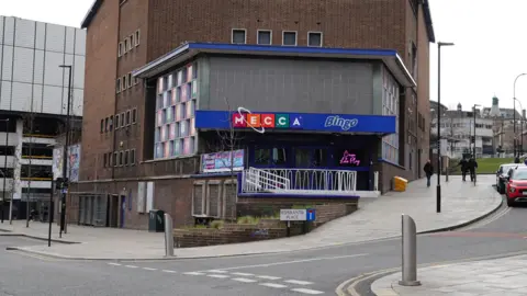 Nigel Harris/iStock Editorial/Getty A street in Sheffield called Esperanto Place. A Mecca Bingo building is behind the sign.