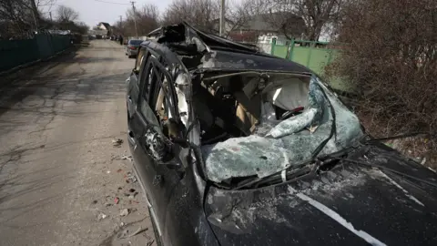 EPA A damaged car is seen at a site of the fighting between Ukrainian and Russian forces on a road leading to the Ukrainian city of Makariv, west of Kyiv,