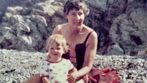Family photo Joyce Currie at the ‘southern cliffs’ end of Fairbourne beach in 1979 with grandson Tom
