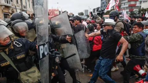 EPA/EFE/REX/Shutterstock Protesters who support the ousted president Pedro Castillo confront the Police on the outskirts of the Prefecture of Lima,