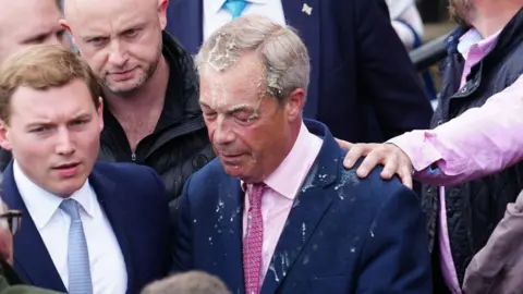 Getty Images Nigel Farage with a drink spilt over his head in a crowd