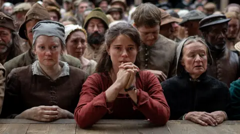 Universal Una imagen fija de Hamnet que muestra el personaje de Jessie Buckley frente a una multitud en el teatro.