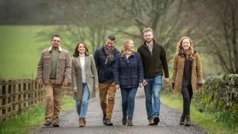 BBC Landward presenters Shahbaz Majeed, Anne McAlpine, Dougie Vipond, Arlene Stuart, Cammy Wilson and Rosie Morton walking along a country path.