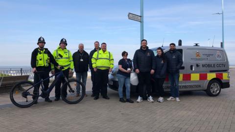 Northumbria Police officers in high vis, members of Nexus and North Tyneside council stood in front of the sea