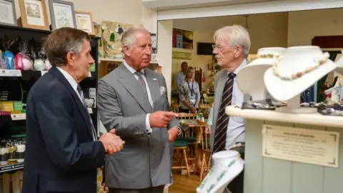 Getty Images Prince Charles look around a gift shop before unveiling a stained glass window at Myddfai Community Hall near Llandovery, Carmarthenshire