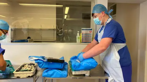 Hywel Dda University Health Board Ryan Davies assisting a healthcare colleague in hospital