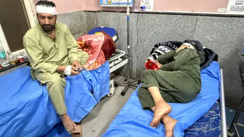 Badrudin and a woman lying in a hospital bed