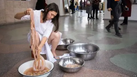 24.kg A young woman washing lamb intestines in a basin