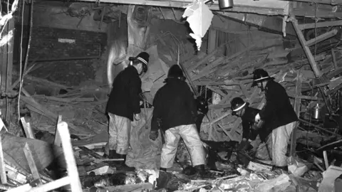 PA Media Firemen at work following the bomb attacks in Birmingham city centre that targeted the Mulberry Bush pub and the Tavern in the Town.