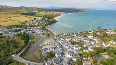 Getty Images Houses and the sea at Abersoch basked in sunshine. The sea is a clear bright blue and there are grassy fields in the background