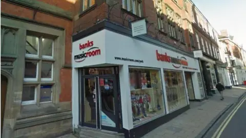 City of York Council/PNW Design Ltd The black and white Banks Musicroom shop front with guitars displayed in the window.