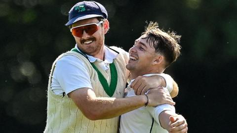 Mark Adair congratulates wicket-taker Curtis Campher at Stormont on Thursday