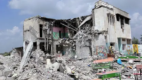Anadolu via Getty Images A view of the debris of a school, where many students and teachers lost their lives on the first day of the wave of attacks