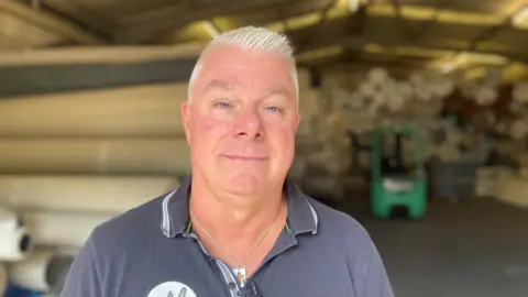 Un hombre de mediana edad mira la cámara