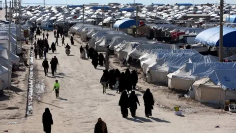 Reuters Women walk through al-Hol displacement camp in Hasaka governorate, Syria