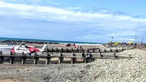 James levett/LoveTywyn A rescue helicopter on the beach at Tywyn