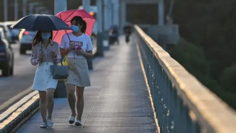 Getty Images Women walking across bridge in Wuhan city