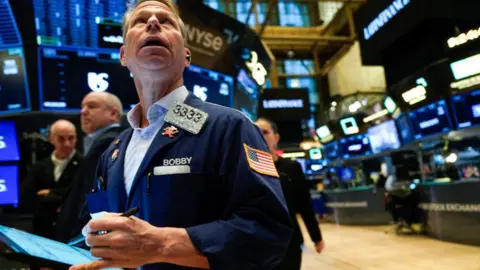 Pedagang Getty Images bekerja di lantai New York Stock Exchange (NYSE) 