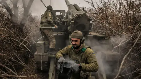 EPA-EFE/REX/Shutterstock Ukrainian soldiers fire a howitzer in the eastern Donetsk region. Photo: November 2024