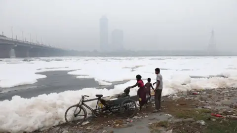 EPA People on the bank of the polluted Yamuna river as the city is engulfed in heavy smog in Delhi, India, 08 November 2023.