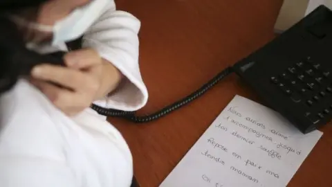 Getty Images In Corsica, a nurse writes down a family message to be placed in the coffin