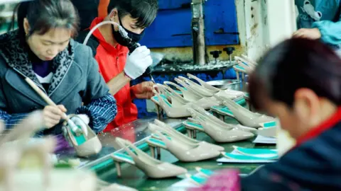 AFP/Getty This photo taken on March 25, 2018 shows Chinese employees producing shoes for export at a factory in Shangrao, in China's central Jiangxi province.