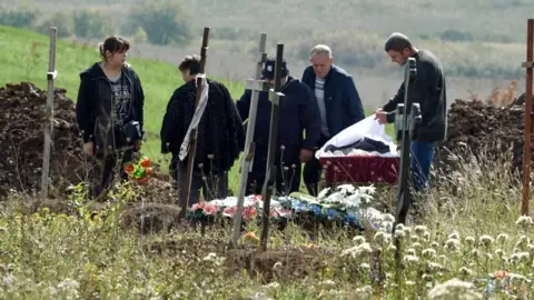 BBC A burial takes place at a cemetery