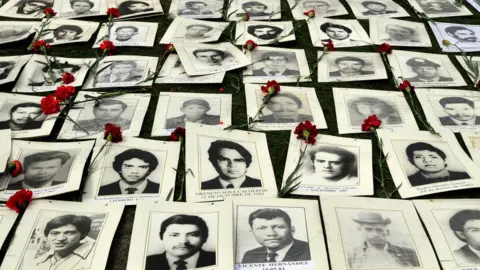 Getty Images Photos of people who disappeared under the military rule of Gen Augusto Pinochet on display at a memorial