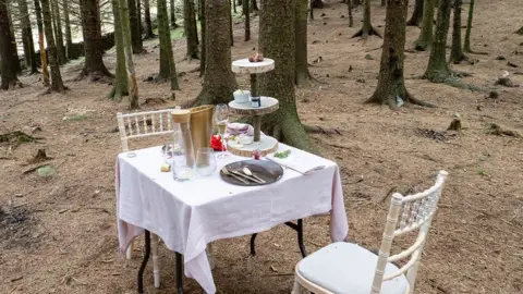 Ashley Cooper GWI Table and two chairs with afternoon tea in wooded area at Blea Tarn