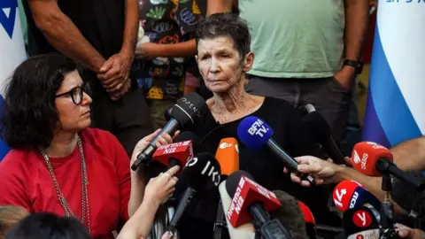 Reuters Released hostage Yocheved Lifshitz speaks to reporters at a hospital in Tel Aviv (24 October 2023)