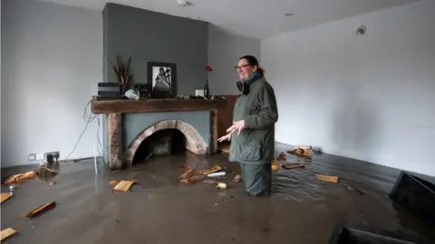 PA Media Gabrielle Burns-Smith at her flooded home in Lymm, Cheshire