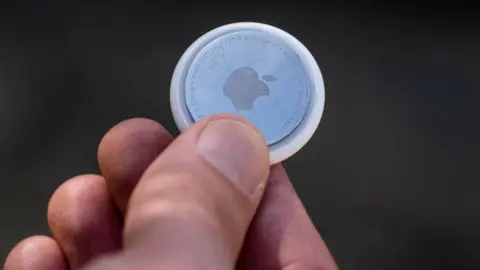 Getty Images A man holding an Apple AirTag