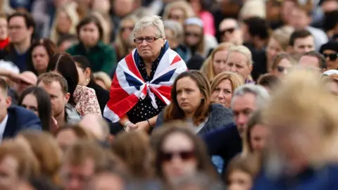 Reuters Woman with a Union Jack flag around her shoulders in a big crowd