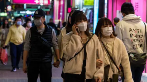 Getty Images Pedestrians on Sai Yeung Choi South Street, in Hong Kong.