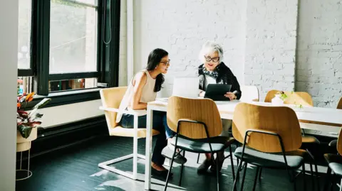 Getty Images two women hold a meeting in a boardroom