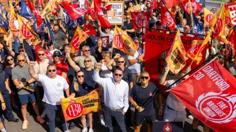 Fire Brigades Union A group of people holding banners and posters. 