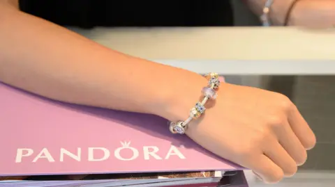 Getty Images A woman's hand wearing a Pandora charm bracelet.