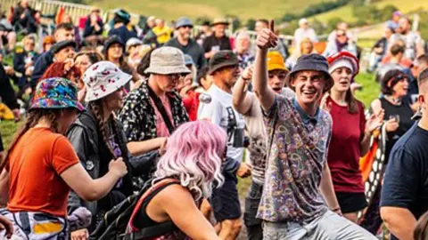 A crowd of people in a field in tshirts and bucket hats
