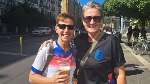BBC Two women in sunglasses smile for the camera, with one holding a drink