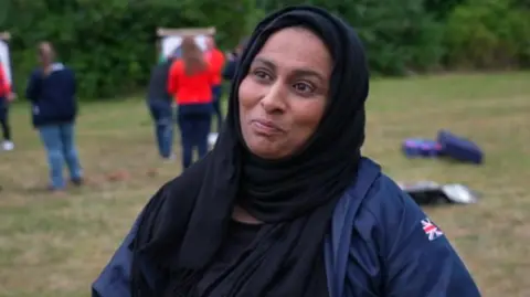 A woman in a hijab standing in a field