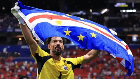 Image of Vozinha raising the Cape Verde flag after their draw against Spain