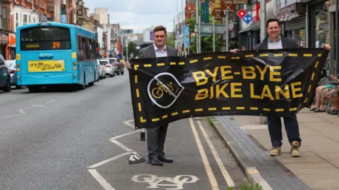 Tees Valley Combined Authority Middlesbrough Mayor Chris Cooke (left) and Tees Valley Mayor Lord Houchen holding a banner reading "Bye-bye bike lane".