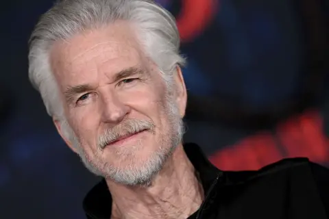 Getty Images Actor Matthew Modine attends the Los Angeles Premiere of Netflix's "Stranger Things" Season 5 - he is an older man with white hair and stubble and he stands in front of a black backdrop with the Stranger Things logo.