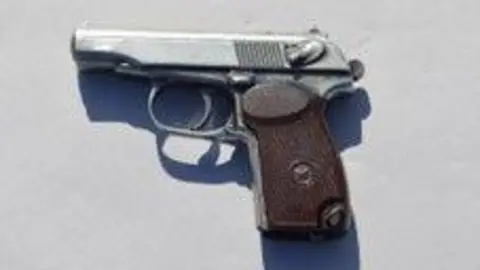Met Police A grainy picture of a small silver pistol with a brown handle.