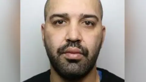 Thames Valley Police A mugshot for Amin Abedi Mofrad, who has a dark beard and is wearing a black jumper and blue T-shirt.