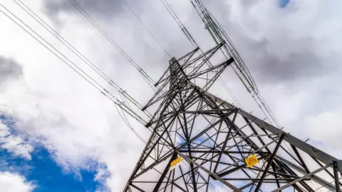 A close up of the top of an electricity pylon taken from below