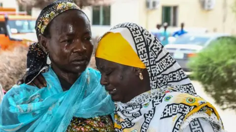 AFP Two women consoling each other following the suicide bombing attacks in Gwoza