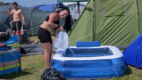 Getty Images A festivalgoer fills her paddling pool at the Isle of Wight Festival at Seaclose Park on June 19, 2025 in Newport, Isle of Wight.