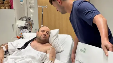 Ahmed Al Ahmed given a GoFundMe cheque in his hospital bed